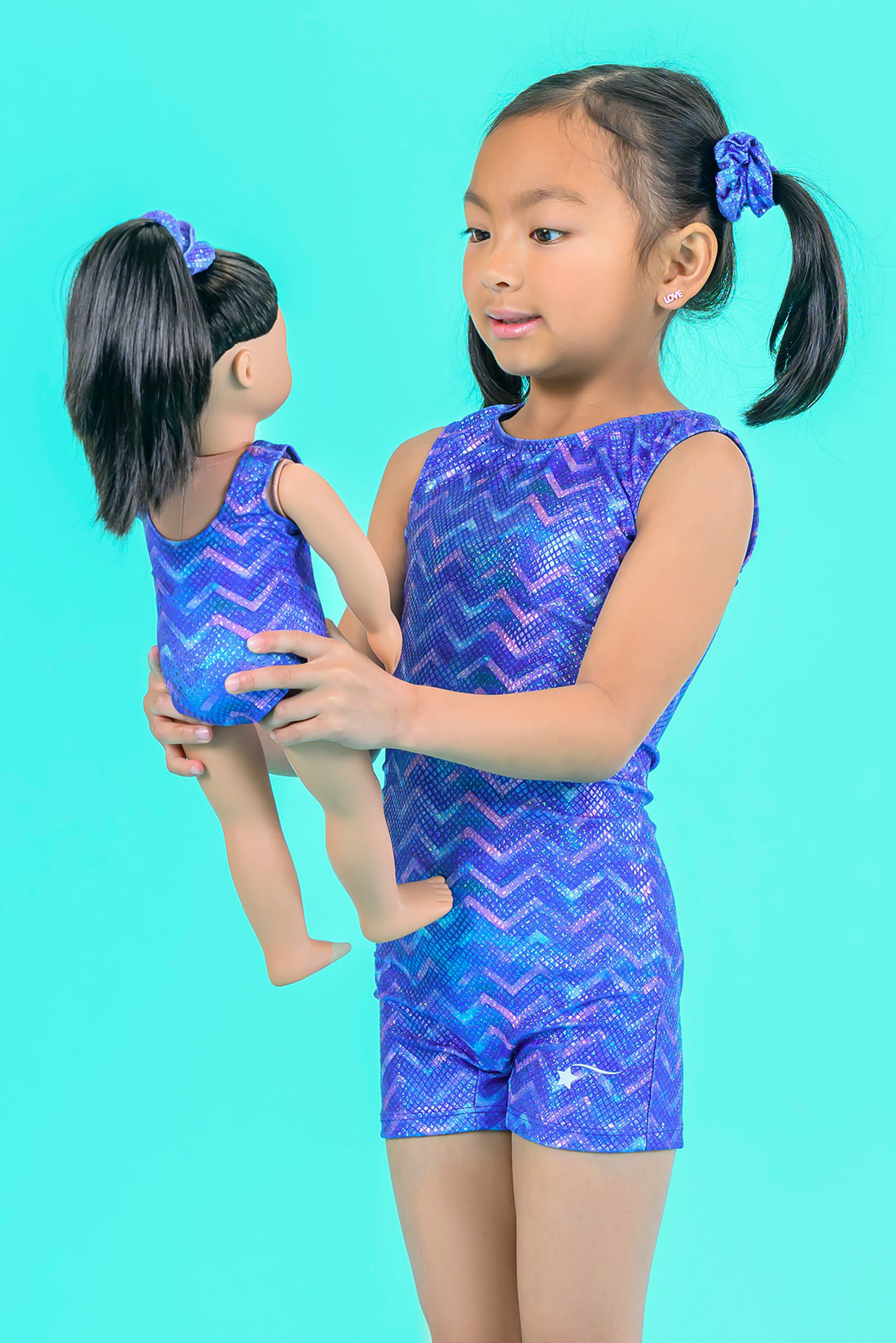 A gymanstic with a blue mermaid biketard with her doll in a matching blue mermaid doll leotard by Destira, 2024