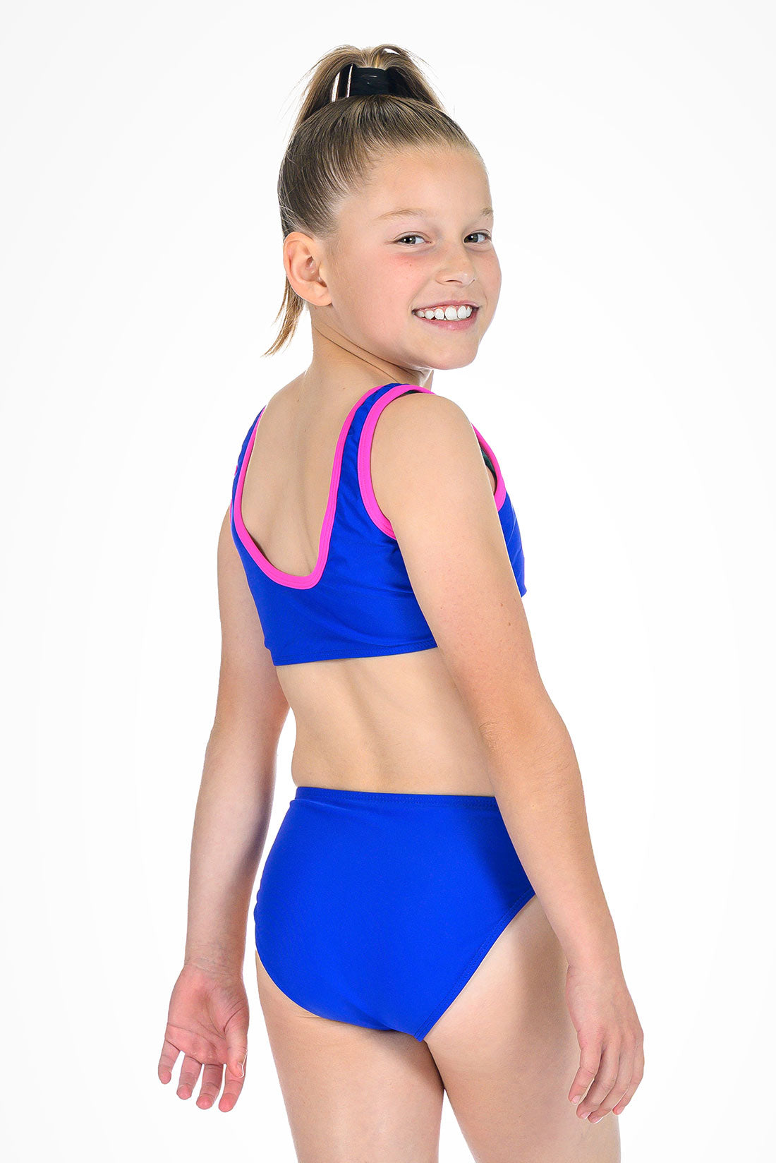 Girl wearing a blue swimsuit with pink trim on a white background showing back view