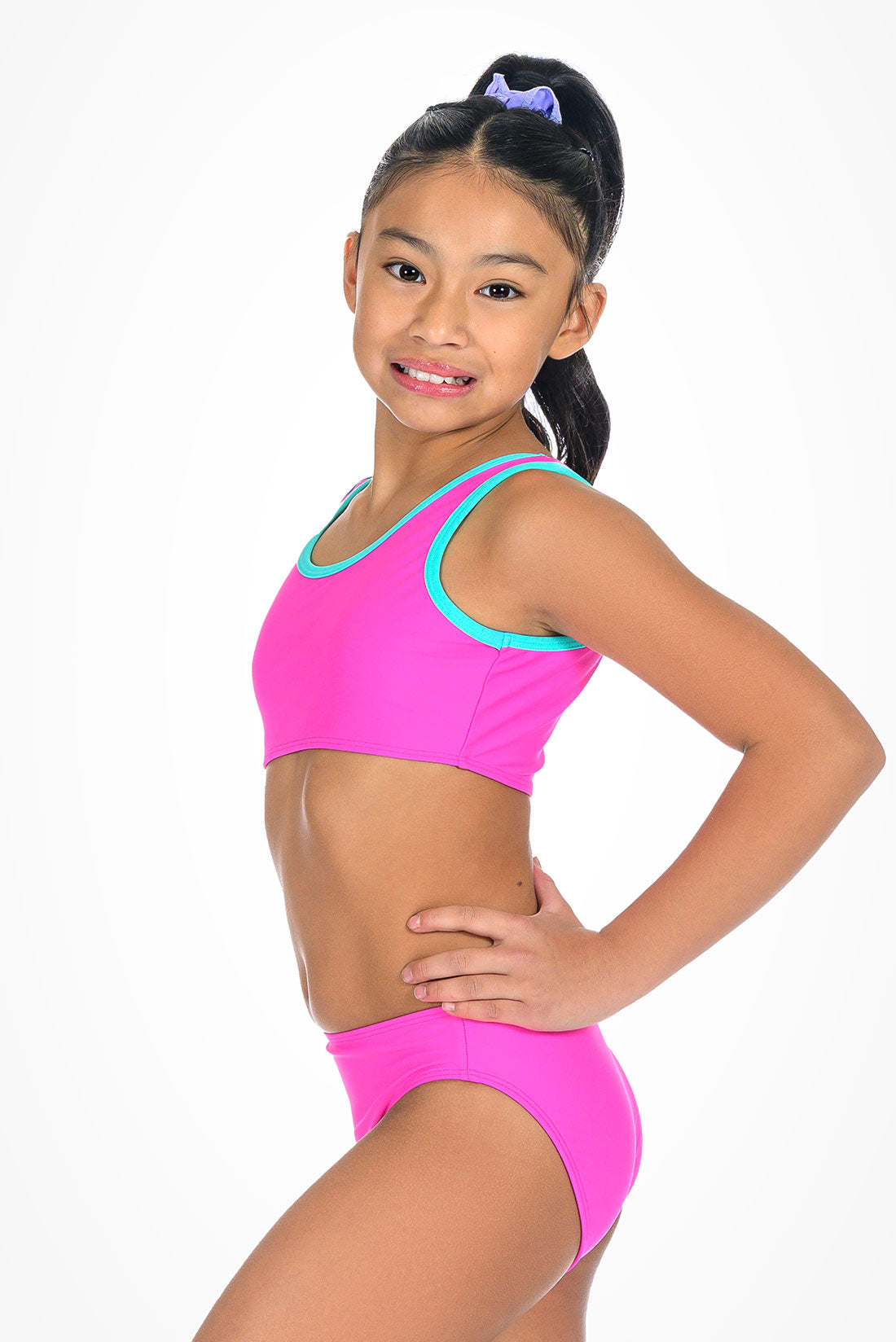 Young girl wearing a pink with turquoise bikini set on a white background showing side view