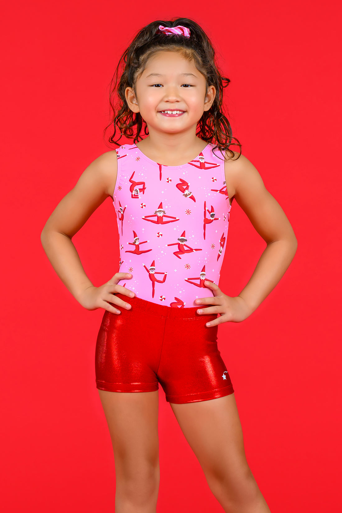 Pink holiday elf leotard and matching shiny red shorts by Destira, 2024